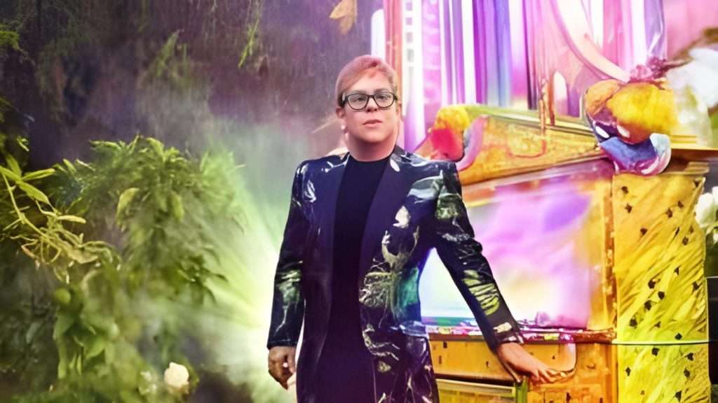 Elton John posing on stage during Farewell Tour.