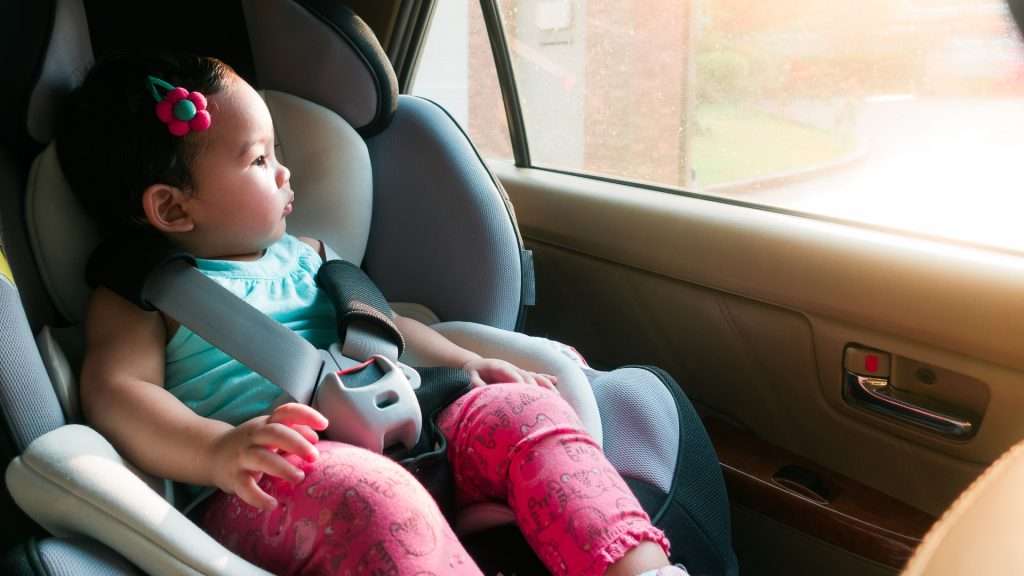 Baby girl in taxi seat looking out window