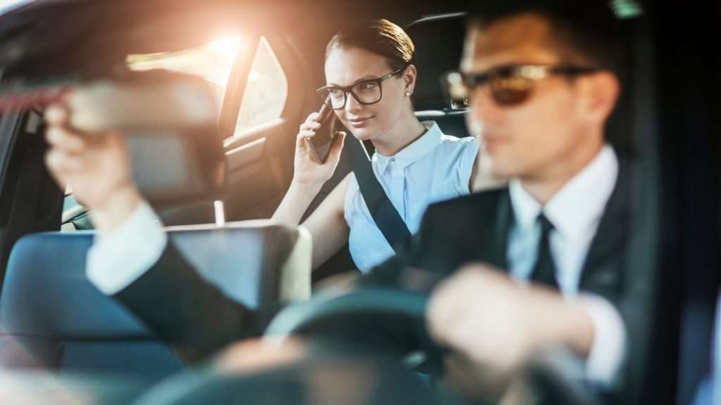 Woman seated in car talking on phone.