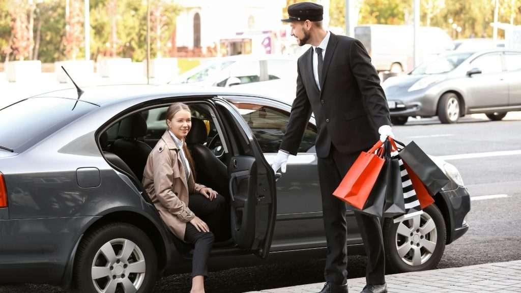 Corporate chauffeur assisting with baggage.