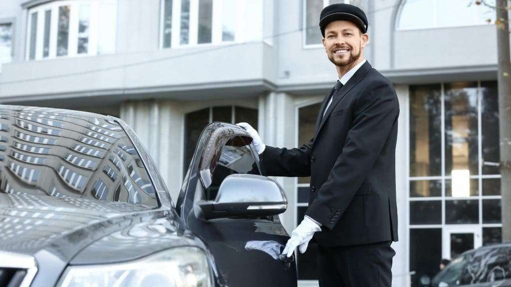 Chauffeurs standing by luxury car at Conference Transfers Gold Coast event