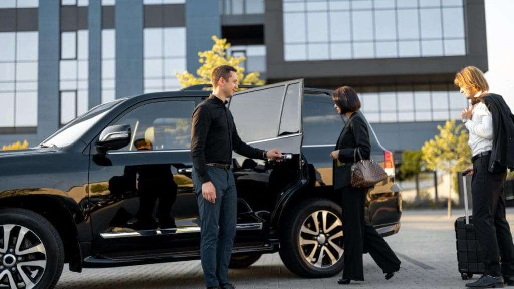 Chauffeurs helping client with Black Cars AusWide service outside luxurious building