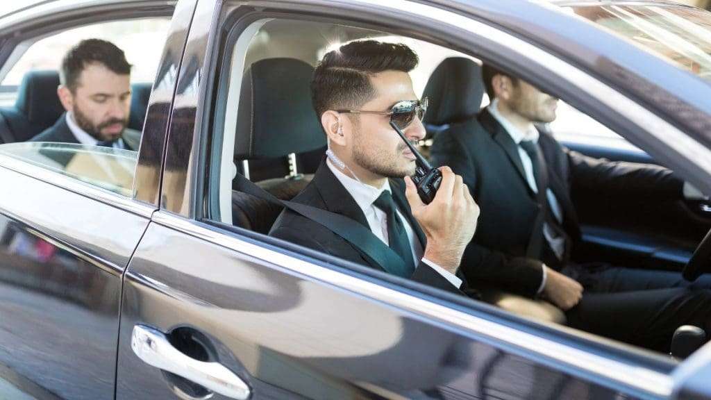 Corporate chauffeur driving luxury car with passenger