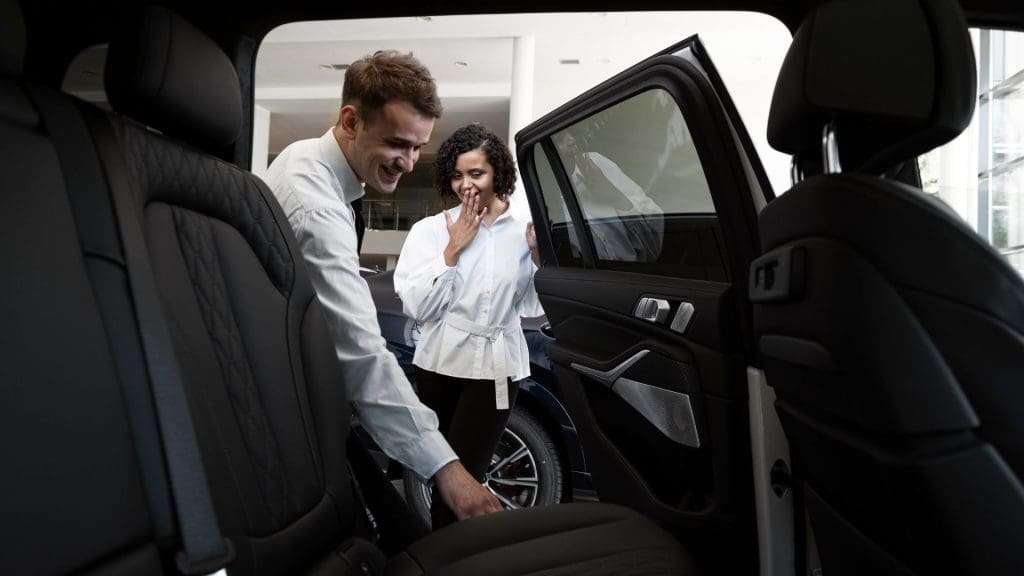 Woman assisted by chauffeurs in tranquil luxury car
