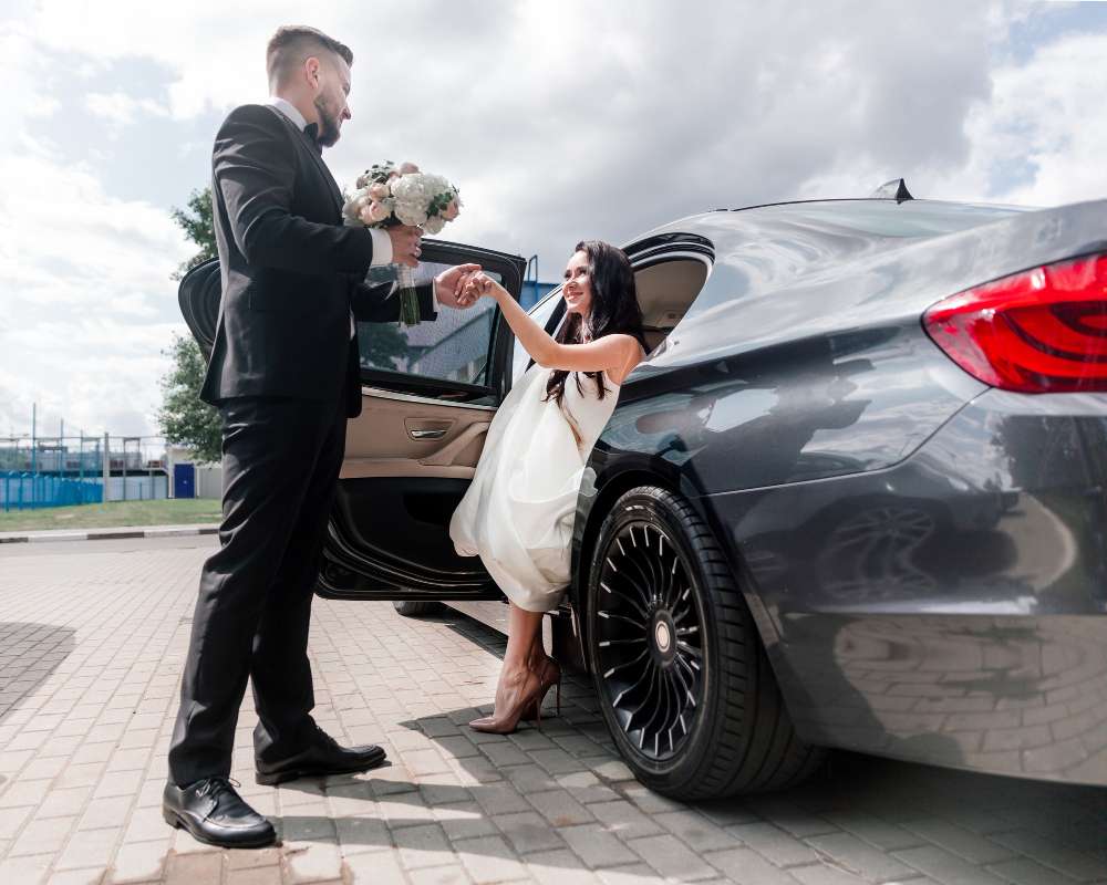 Happy couple in wedding car, corporate chauffeurs service.