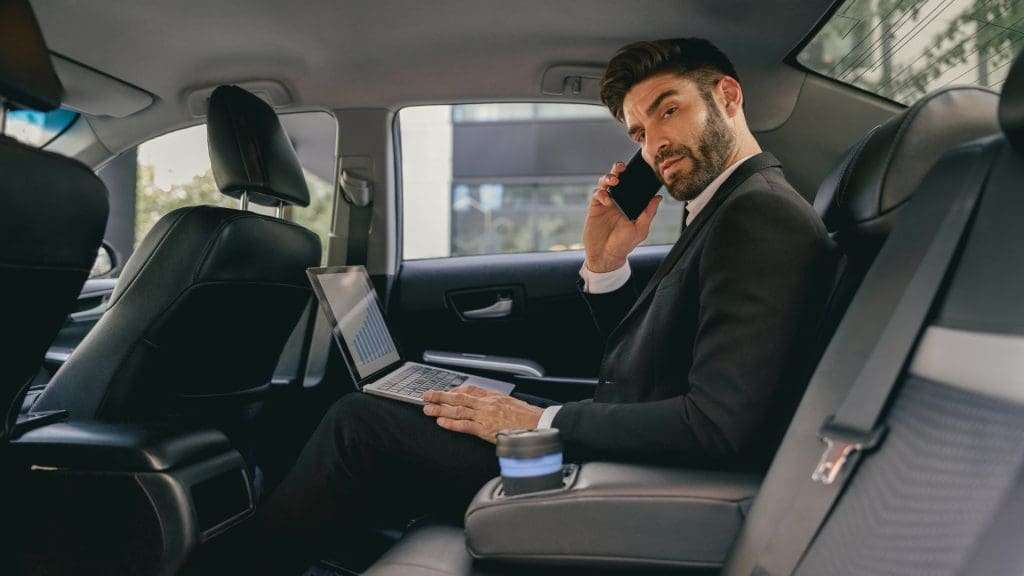 Corporate Chauffeur Service with executive using laptop