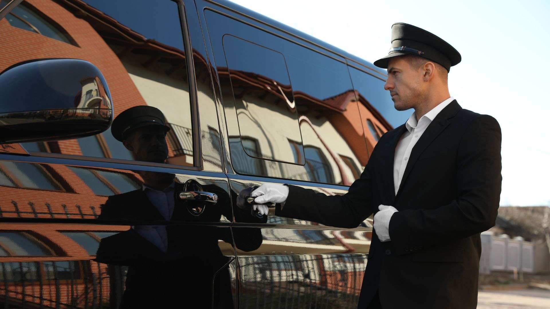 private chauffeur hire standing beside luxury vehicle